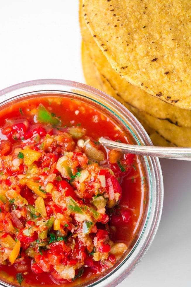 A bowl of fresh Roasted Red Pepper Salsa served with fish A bowl of vibrant roasted red pepper salsa placed next to a grilled fish fillet
