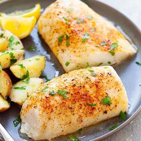 A plate of perfectly Baked Cod A perfectly baked cod fillet garnished with fresh parsley and lemon slices