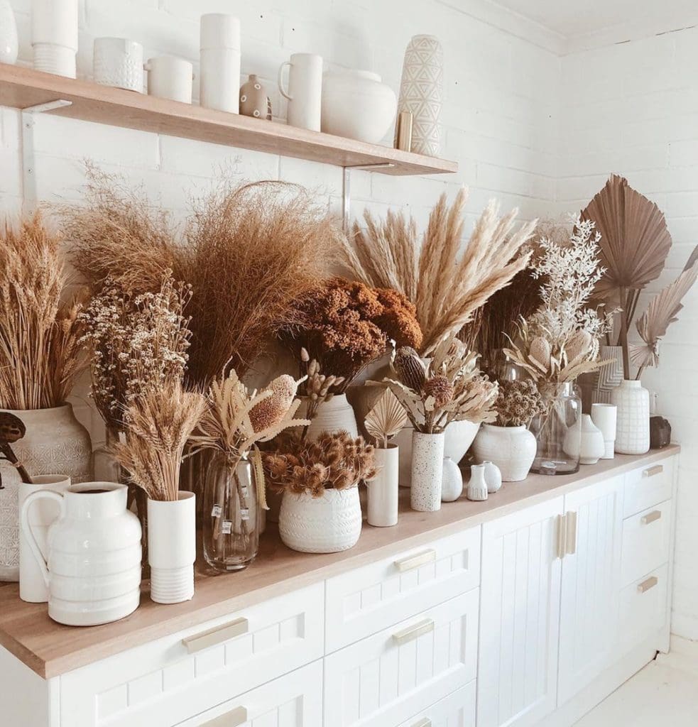 A massive dried flower vase arrangement A large, stunning arrangement of colorful dried flowers sitting in a white vase