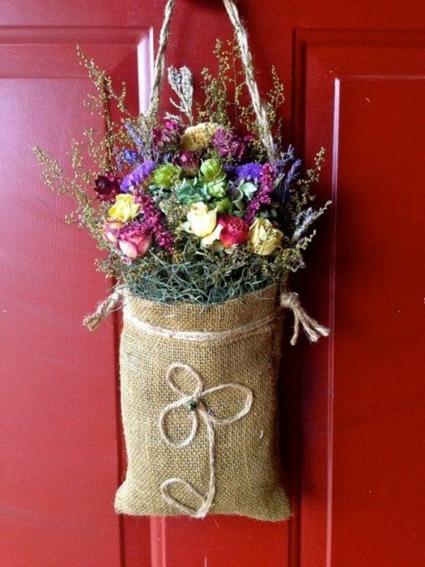 Dried flowers hanging on a rustic wooden door A beautiful, simple bunch of dried flowers hanging from a rustic wooden door knob