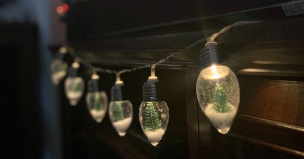 A close-up of beautiful Mini Snow Globe Lights A string of Christmas lights where each bulb looks like a miniature snow globe with a tiny tree inside