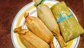 Chanchamitos Tamales A row of small, round Chanchamito tamales tied at both ends with corn husks.