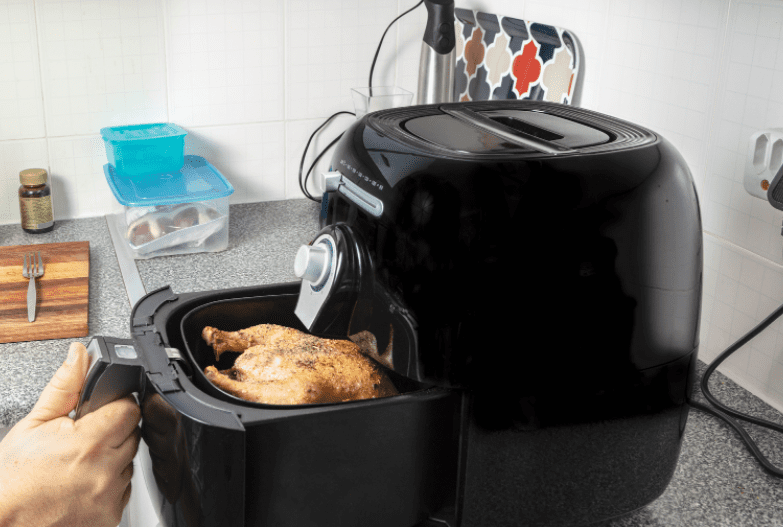 Air Fryer Vs Convection Oven A sleek modern air fryer sitting next to a stainless steel countertop convection oven.