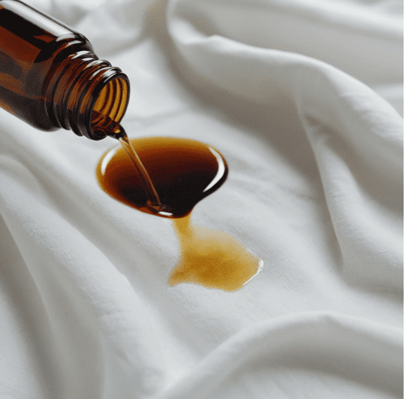 Stain on a white shirt being treated with essential oil solution Stain on a white shirt being treated with essential oil solution