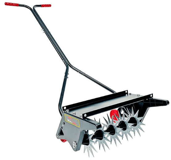 Brinly PA-403BH 40-Inch Tow-Behind Plug Aerator attached to a riding mower, with the weight tray loaded, actively pulling soil plugs.