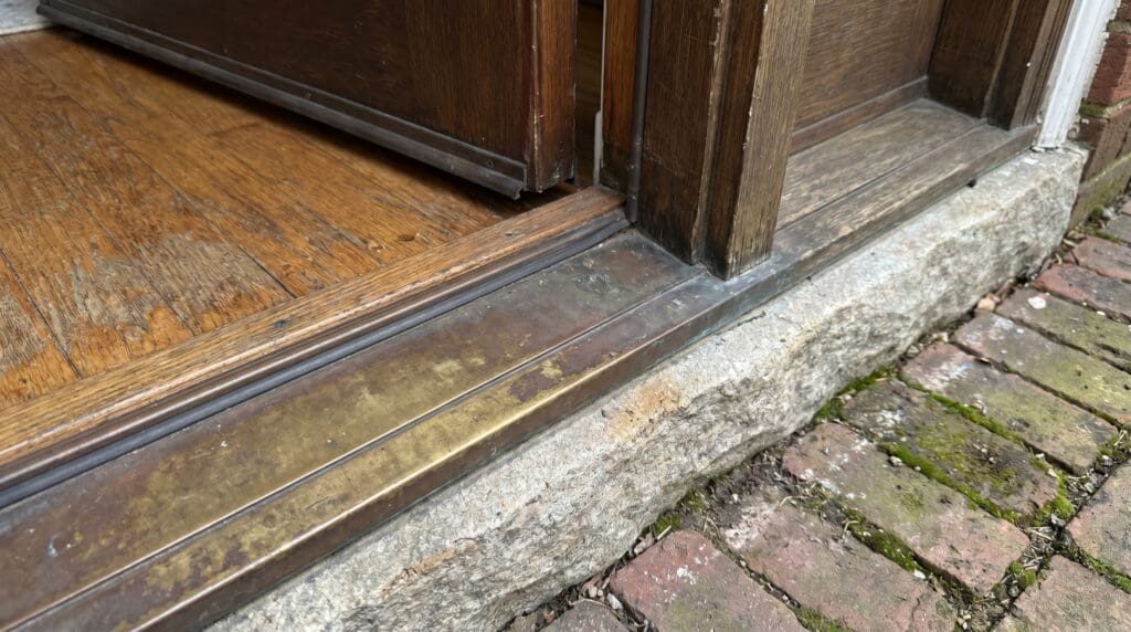 Exterior door sill plate and threshold at the bottom of a front entry door Exterior door sill plate and threshold at the bottom of a front entry door