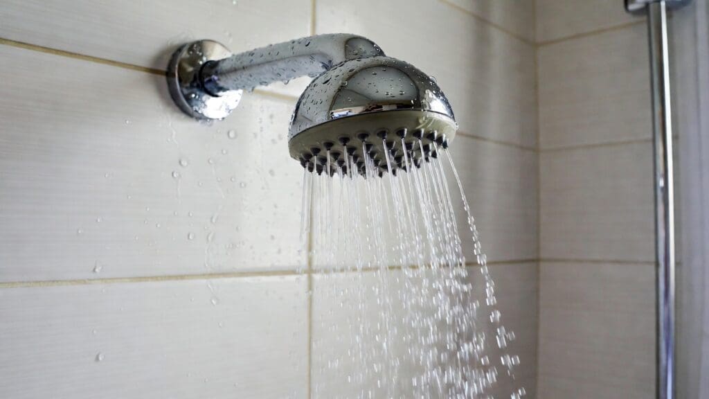 Chrome shower head spraying focused water streams in a modern bathroom Gardenfrontier Chrome shower head spraying focused water streams in a modern bathroom